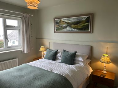 A bedroom with a bed and window at The Anchorage in Abersoch