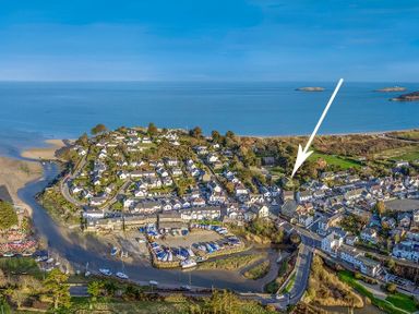 An aerial view of a coastal village with houses boats and a harbor at The Coach House in Abersoch