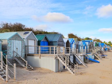 A row of beach huts with stairs leading down to the sand at The Warren D26 in Abersoch