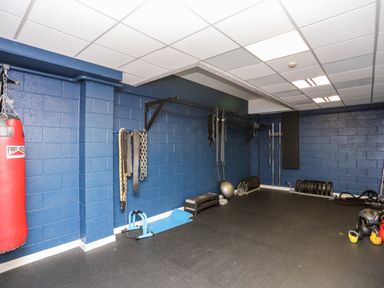 A gym room with a punching bag kettlebells weights and exercise equipment at The Warren D26 in Abersoch