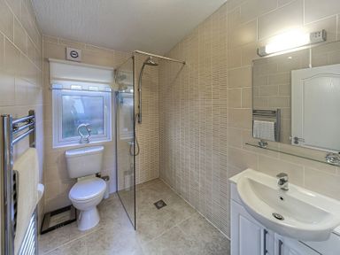 A bathroom with a shower, toilet, and sink at The Warren D7 in Abersoch
