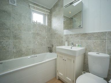A bathroom with a bathtub shower sink and toilet at The Warren T23 in Abersoch
