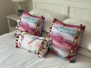 A bedroom with decorative pillows on a bed at Ty Coed in Abersoch