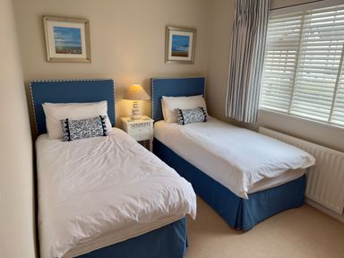 A bedroom with two single beds and a lamp at Ty Coed Abersoch