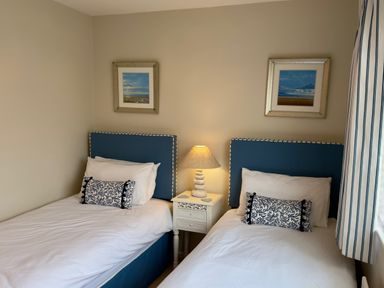 A bedroom with two beds and a bedside table at Ty Coed in Abersoch