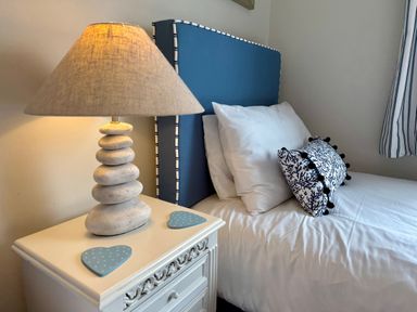 A bedroom with a bed and bedside lamp at Ty Coed Abersoch
