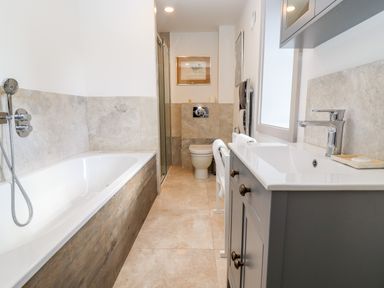 A bathroom with a bathtub shower toilet and sink at Stow Cottage Barn in Churchill Oxfordshire