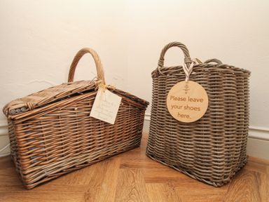 Two wicker baskets on a wooden floor with tags attached at The Coach House at Lackington Farm in Piddletrenthide