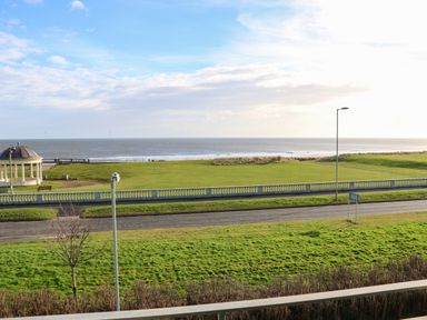 A seafront view with a grass park and a road in front at Sandy Corner in Blyth Northumberland