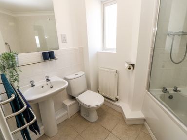 A bathroom with a sink toilet shower and a window at Sandy Corner in Blyth Northumberland