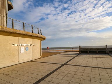 An exterior view of the Dave Stephens Centre with a tiled walkway and the sea in the background at Sandy Corner in Blyth Northumberland