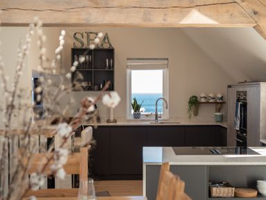 A kitchen with wooden beams and a window overlooking the sea at Church Rooms in Port Isaac