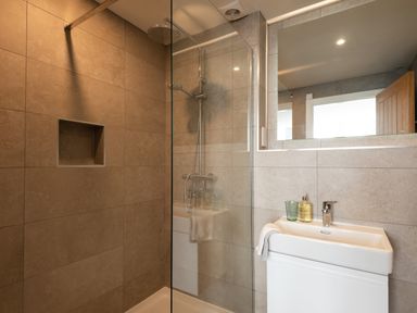 A bathroom with a walk-in shower and a white sink with a mirror above at Church Rooms in Port Isaac