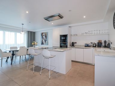 A kitchen with a dining table and appliances at 13 Cliff Edge in Newquay