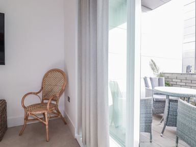 A balcony with a chair and table at 13 Cliff Edge in Newquay