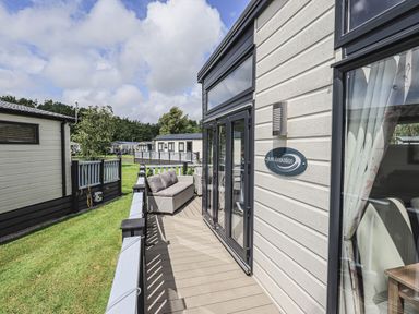 Exterior balcony with seating area and glass doors on a house at Yealands 27 in South Lakeland Leisure Village near Carnforth