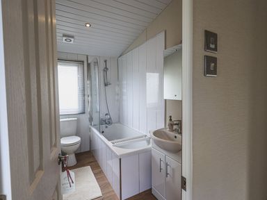 A bathroom with a bathtub shower toilet and sink at Yealands 27 South Lakeland Leisure Village near Carnforth
