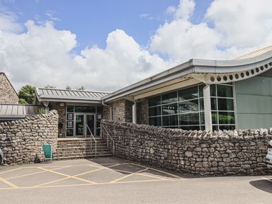 An entrance to a building with stone walls steps and a railing near South Lakeland Leisure Village near Carnforth