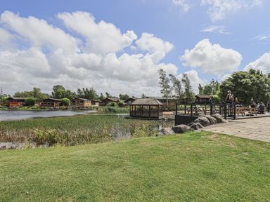 A lakeside view with wooden cabins small gazebo and outdoor dining area at Yealands 27 in South Lakeland Leisure Village near Carnforth