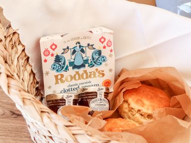 A basket with scones jam and clotted cream in a kitchen setting at Sea View in St Buryan