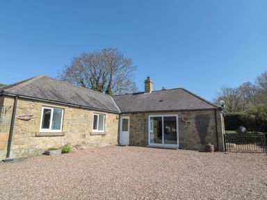 A house with a gravel area and trees at Whinney Moor in 