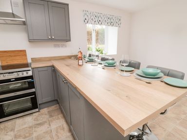A kitchen with cabinets and a dining area at Whinney Moor