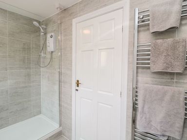 A bathroom with a shower and towel rail at Whinney Moor