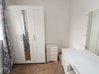 A bedroom with furniture including a wardrobe and vanity unit at Whinney Moor 