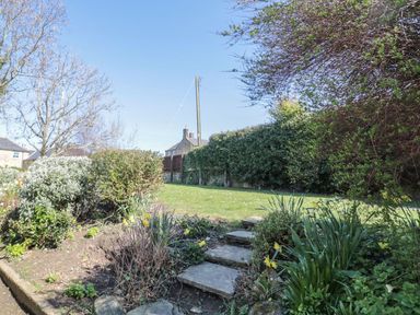 A garden with a pathway and flower beds at Whinney Moor 