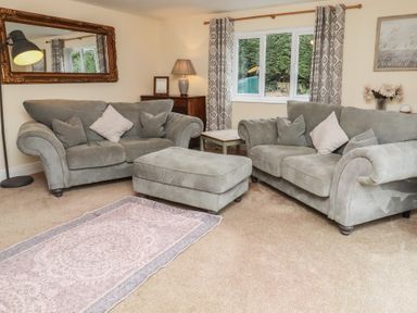 A living room with sofas and a decorative rug at Whinney Moor in Alnwick