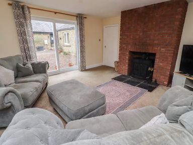 A living room with a sofa and fireplace at Whinney Moor in Alnwick