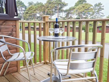 A table with a wine bottle and glasses on a balcony at Bugle Saltburn-By-The-Sea