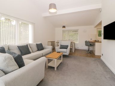 A living room with sofas coffee table dining table and chairs at Harcombe House Bungalow 3 in Chudleigh