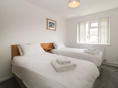 A bedroom with two single beds and towels on the beds at Harcombe House Bungalow 4 in Chudleigh