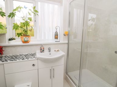 A bathroom with a sink countertop with mosaic tiles and a shower enclosure at Tartaria in Widdrington