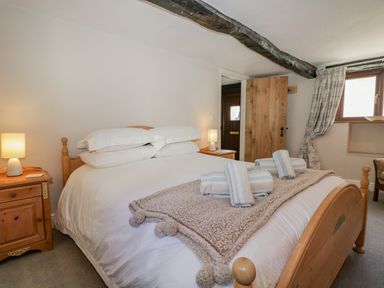 A bedroom with a wooden bed and bedside tables with lamps at Ashness in Bassenthwaite near Keswick