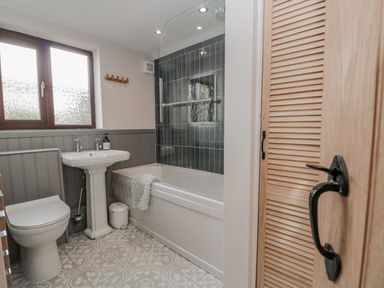 A bathroom with a toilet sink bathtub and tiled floor at Ashness in Bassenthwaite near Keswick
