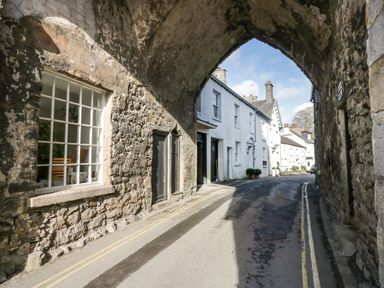 A street with stone archway and white buildings along the road at 1 Tower House in Cartmel