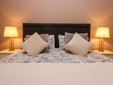 A bedroom with a bed and bedside lamps at 1 Tower House in Cartmel