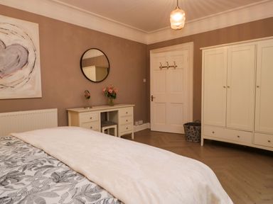 A bedroom with a bed and wardrobe at 1 Tower House in Cartmel
