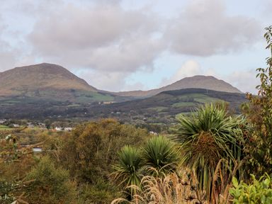 A landscape view featuring hills, trees, shrubs, and a cloudy sky at Seascape Lodge in Kenmare County Kerry