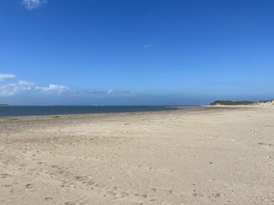 A beach with sand and ocean at Apple Barn in South Molton
