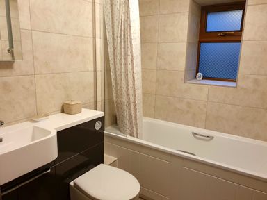 A bathroom with a bathtub shower curtain toilet and sink at Ty Barcud in Llanfair Clydogau