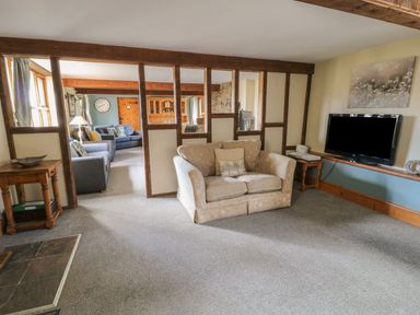 A living room with a sofa television and wooden furniture at Hazel Barn in North Molton