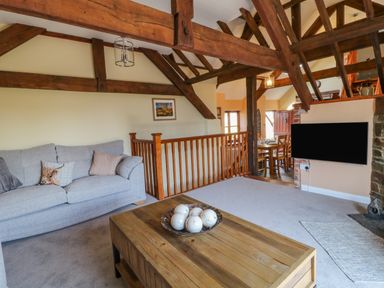 A living room with a gray sofa and wooden coffee table with decorative balls at Oak Cottage in North Molton