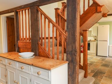 A kitchen and staircase with wooden beams and cabinets at The Hawthorns in North Molton