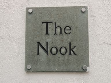 A stone plaque with the text The Nook mounted on a white wall at The Nook in Whitby