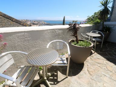 A terrace with chairs and a table at Heron in St Ives