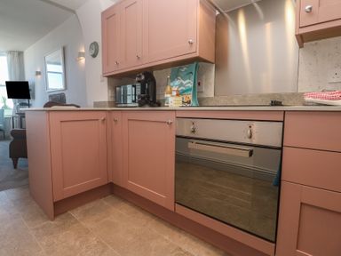 A kitchen with pink cabinets and appliances at Heron in St Ives