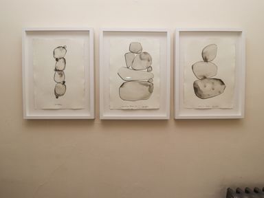Three framed abstract ink paintings of stacked stones on a wall at Whistler in St Ives